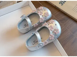 Detailed view of silver girl's princess shoes featuring pink embroidered flower patterns