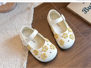 Close-up detail of white girls' Mary Jane princess shoes with yellow flower embroidery