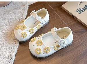 Close-up of white Mary Jane shoes for girls with elegant yellow floral embroidery details
