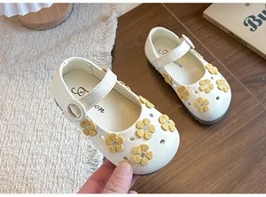 Close-up of elegant white Mary Jane shoes featuring delicate yellow flower appliques for girls.