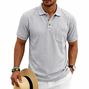 Detail of light grey waffle knit polo shirt showing chest pocket and texture.
