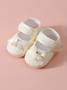 Elegant off-white lace baby girl princess shoes with delicate pearl and bow accents
