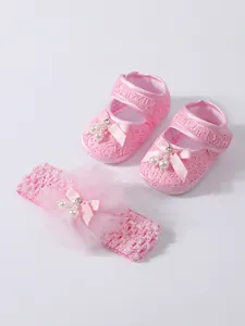 Detailansicht von rosa Spitzen-Babyschuhen mit passendem Stirnband-Set mit Schleifen