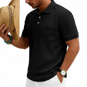 Close-up of men's black waffle knit polo shirt showing heavy texture and pocket detail.