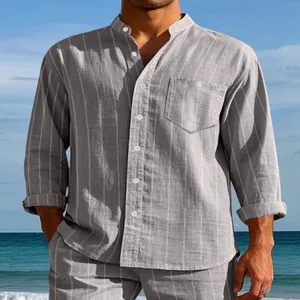Vista detallada de una camisa de lino a rayas grises para hombre con cuello mao en playa.