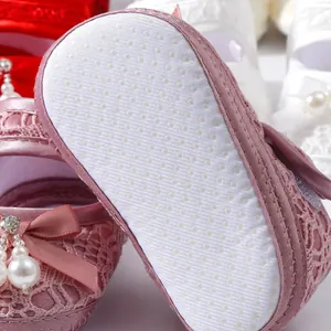 Nahaufnahme von Neugeborenen-Babyschuhen mit weicher Sohle und rutschfesten Noppen.