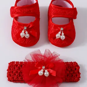 Rote Babyschuhe und Stirnband-Set mit Schleifen und Perlen für festliche Babybekleidung.