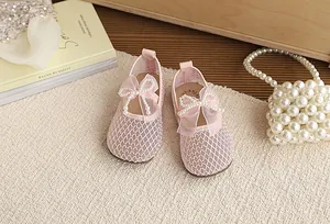 Close-up of pink breathable mesh girl's princess shoes featuring a pearl bow