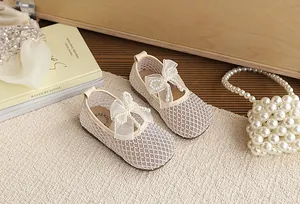 Detailed view of beige mesh girl's princess shoes with elegant pearl bow decoration