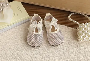 Detailed close-up of beige mesh princess shoes featuring elegant lace and pearl bow decoration.