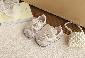 Detailed close-up of breathable mesh ballerina flats with pearl bow for little girls.