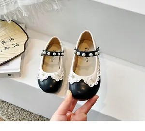 Nahaufnahme von schwarz-weißen Mädchen-Prinzessinnenschuhen mit Perlen und Wellenrand