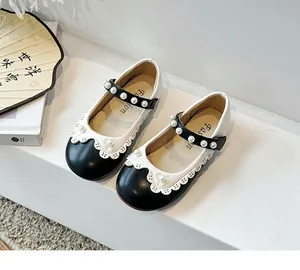 Detailansicht der schwarz-weißen Mary Jane Prinzessinnenschuhe für Mädchen mit Perlen