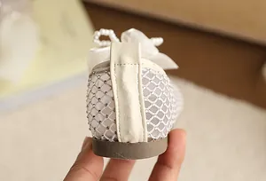 Close-up back view of girls' mesh princess shoe with rhinestone details and pearl bow