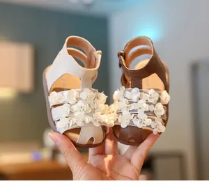 Detalle de sandalias de princesa para niña con elegantes flores de lentejuelas en 3D