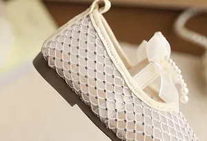 Detailed close-up of breathable mesh girls' princess shoe with rhinestones and pearl bow