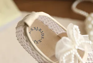 Close-up detail of breathable mesh princess shoe for girls with elegant pearl-beaded bowknot