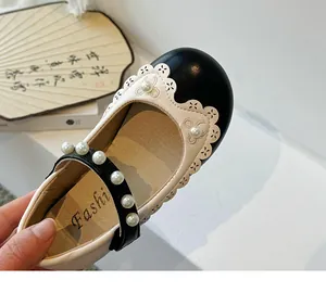 Detailansicht der Mädchen Prinzessin Schuhe mit Spitzenkante und Perlenriemen Verzierung.