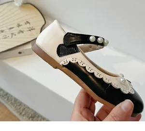 Detailansicht eleganter schwarz-weißer Prinzessinnenschuhe für Mädchen mit Perlenverzierung