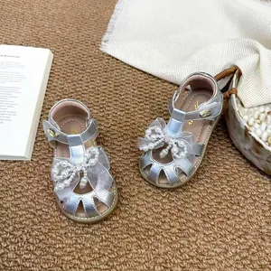 Vue détaillée de sandales argentées pour filles avec nœud en perles et maille fine.
