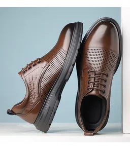 Close-up detail of brown men's leather dress shoes with decorative perforations and laces