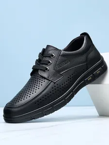 Close-up of black perforated business casual shoes for men with textured leather