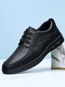 Detailed view of black perforated leather men's business casual dress shoe with laces