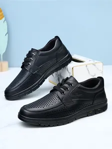 Breathable men's black leather business casual shoes featuring a perforated hollow-out design.