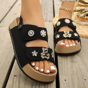 Modische schwarze Plateausandalen mit Bärenanhängern für sommerliche Strandkleidung.