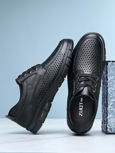 Close-up view of black perforated leather business casual shoes with lace-up detail