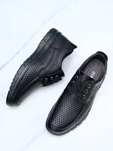 Close-up detail of black perforated leather business casual shoes with soft texture