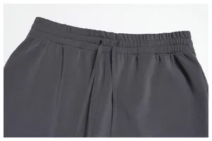 Detail of dark grey modal sports trousers showing elastic waistband and drawstring.
