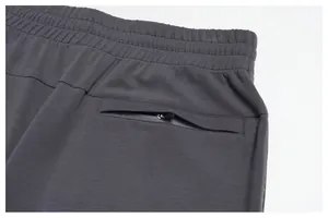 Close-up of men's jogger pants showing elastic waistband and hidden zipper pocket