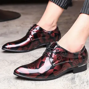 Detailed view of men's glossy patent leather dress shoes with floral pattern