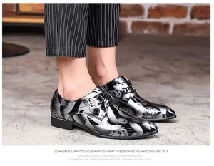 Close-up of men's mirror finish dress shoes with floral pattern on model