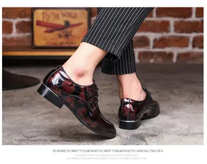 Elegant side view of shiny maroon patterned Oxford shoes with pinstripe trousers