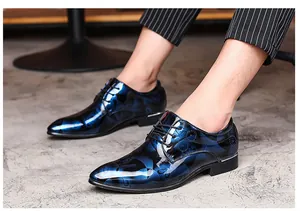 Detail of blue floral patterned men's formal dress shoes with a glossy mirror finish.