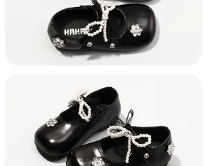 Dettaglio delle scarpe da principessa nere per bambine con fiocchi di perle e strass