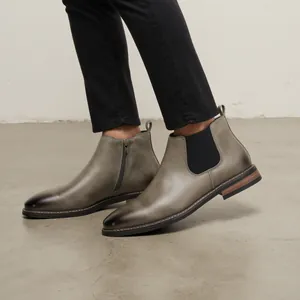 Gros plan de bottines Chelsea classiques en cuir gris dégradé pour hommes portées