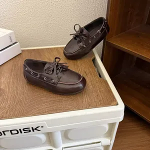 Détail de mocassins marron foncé pour filles style britannique avec nœud et semelle souple