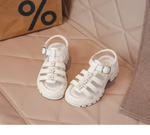 Détail de sandales romaines blanches pour filles avec fleurs et boucles élégantes