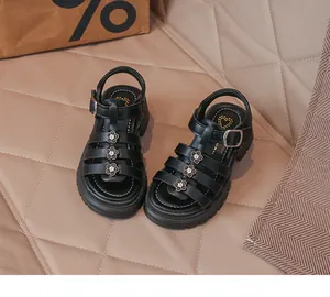 Détail de sandales romaines noires pour filles avec décorations florales et boucle