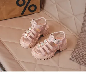 Vue rapprochée de sandales romaines roses pour filles avec fleurs sur cuir matelassé