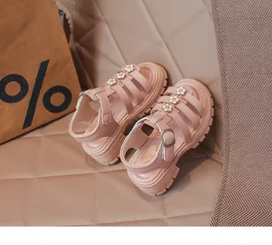 Détail de sandales gladiateur roses pour filles avec fleurs et semelles épaisses