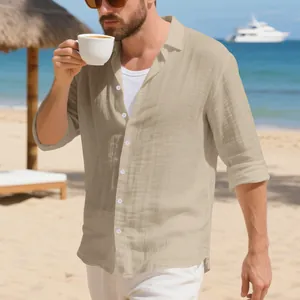 Uomo con camicia di lino beige che beve caffè in una splendida cornice di spiaggia tropicale.