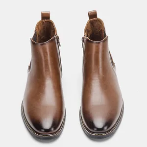 Vue de face de bottines Chelsea classiques en cuir marron pour hommes avec fermeture éclair.