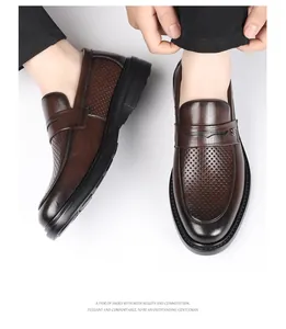 Detailed view of men's brown perforated leather business casual loafers with thick black soles