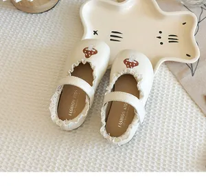 Close-up detail of cream girls' Mary Jane shoes featuring lace trim and cute mushroom embroidery