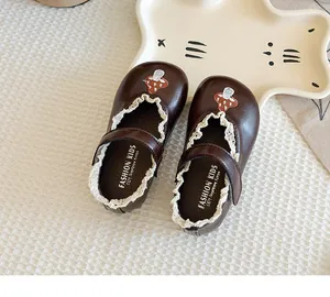 Detailed macro view of brown girls Mary Jane shoes featuring cute mushroom embroidery and lace.