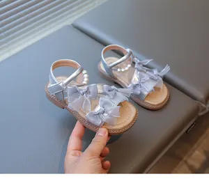 Detailed view of silver girls' princess sandals with mesh bows and pearl accents